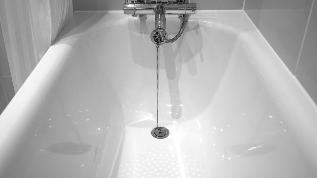 Ein Schwarzweiß-Foto einer Badewanne mit Wannenarmatur des Typs Thermostats.